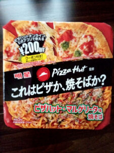 ピザハットのマルゲリータ味焼きそばのパッケージ。おいしさとクーポン情報が記載されています。